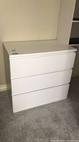 Front and side view of white 3-drawer dresser