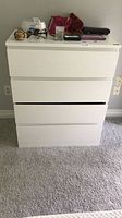 Front view of white 4-drawer dresser showing top surface and drawer alignment