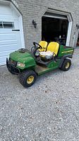 Front left view of John Deere UTV showing brush guard, two seats, and overall body