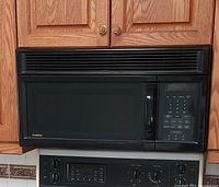 Front view of installed black Goldstar over-range microwave