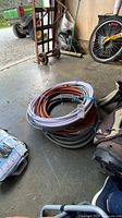 Stack of four coiled hoses on garage floor