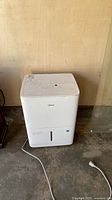 Front view of white Midea dehumidifier with cord
