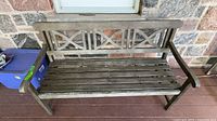 Front view of wooden bench showing full design and slatted seat