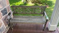 Front view of wooden garden bench on porch showing full structure