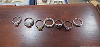 Lineup of all seven rings showing designs and stones
