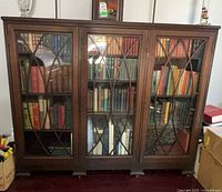 Front view of wooden bookcase with three leaded glass doors