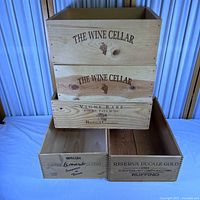 All five wooden wine crate bottoms stacked showing branding fronts