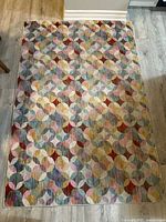 Full view of multicolor geometric area rug on floor
