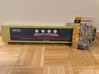 Boxed 4-light vanity fixture alongside blister pack of four Sylvania bulbs