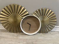 Two gold metal wall accents and wood-face clock front view