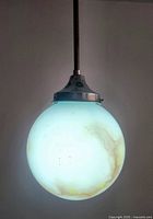 Illuminated slag glass globe close-up showing color and veining