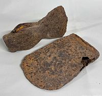 Two rusted metal axe heads side by side