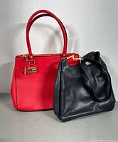 Red Aldo tote and black shoulder bag side by side
