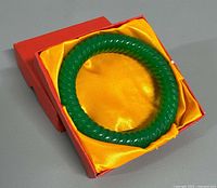 Bangle in open red box with yellow satin lining