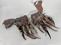 Both copper articulated hand claw gauntlets side by side