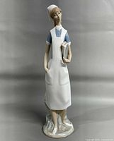 Full view of Lladró nurse figurine against neutral backdrop