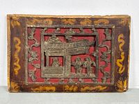 Front view of carved wood plaque showing scene and painted border