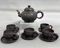 Full tea set: teapot on stand with four cup-saucer sets