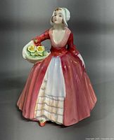 Front view showing full figure, dress colors and flower basket