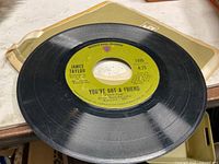 A-side of James Taylor 45 rpm single showing title "You've Got a Friend", catalog number 7488, on green Warner label, sleeve visible underneath