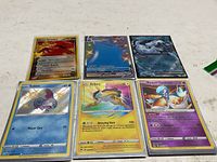 Six Pokémon cards laid out in two rows of three, all in protective sleeves
