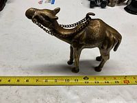 Right side view of brass camel showing chain reins and ruler indicating length