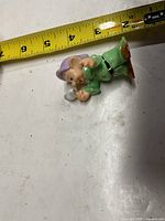 Full view of Dopey figurine beside tape for scale