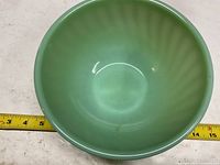 Top view of jadeite bowl showing interior and measurement tape indicating approx 8 in diameter