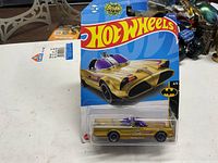 Front view of sealed Hot Wheels gold Batmobile in package
