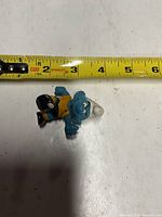Front view of Smurf figurine with tape measure indicating length