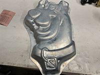 Front view of embossed aluminum Scooby-Doo cake pan showing full design and surface wear