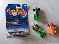 Front view showing sealed Splittin' Image II blister card and three loose cars