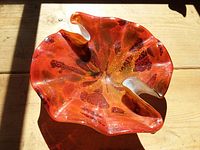 Top view showing red-orange glass dish with ruffled edges and gold flecks