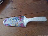 Top view of porcelain cake lifter showing floral blade and ivory handle