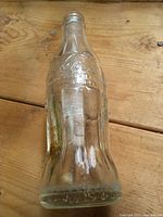 Side view of entire Coca-Cola glass bottle showing embossing and shape