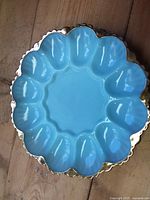Top view showing blue milk glass platter with 12 egg wells and gold rim