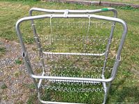 Bed folded upright showing tubular frame and spring grid