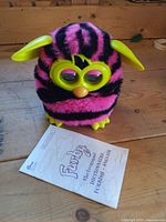 Front view of Furby with instruction manual