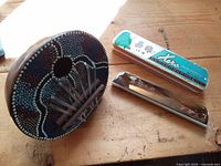 Harmonica in box and coconut shell kalimba on wooden surface