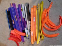 Pile of assorted Hot Wheels track sections in multiple colours and shapes