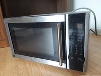 Front view of GE stainless steel microwave showing door, handle and control panel