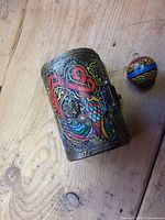 Side view of painted chest and pendant bead