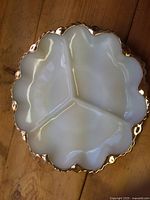 Top view of milk glass dish showing three compartments and gold scalloped rim