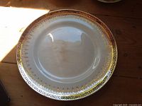 Front of white plate with gold and red rim