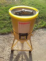 Full view of yellow wheeled sandblaster tank with logo and label