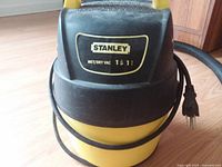 Front view of Stanley wet dry vacuum showing brand label, power cord, yellow body