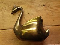 Left side view of brass swan dish showing overall shape and smooth finish