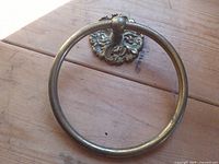 Front view of brass towel ring and ornate backplate