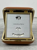 Front view showing Hamilton brand, jump-hour window, minute scale and alarm indicator