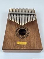Front view of Yael Y17 wooden kalimba showing tines, soundhole and logo plate